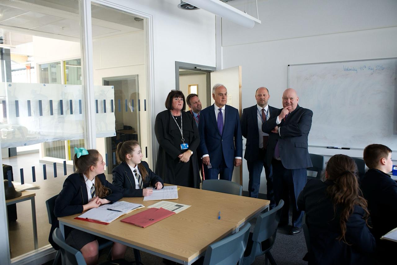 A group of school leaders and mentors observing students in a classroom