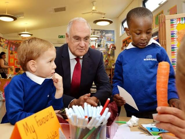 Sir Michael Wilshaw speaking with pupils in a primary school classroom